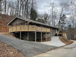 ein Haus mit einer Terrasse an der Straßenseite in der Unterkunft Fabulous 4Bed 3 bath Cottage Pool Hot tub Games in Gatlinburg