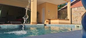 ein Haus mit einem Pool mit einem Brunnen in der Unterkunft Casa Espetacular Piscina Aquecida Ofuro Sauna in Caraguatatuba