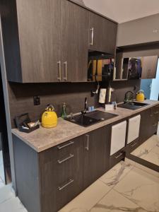 a kitchen with wooden cabinets and a yellow bowl on the counter at P6 Apartament Mini Light Black in Pisz