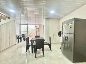 a dining room with a table and a refrigerator at Casa colonial - Jacuzzi - cerca al parque principal - lundry - Tv in Santa Fe de Antioquia