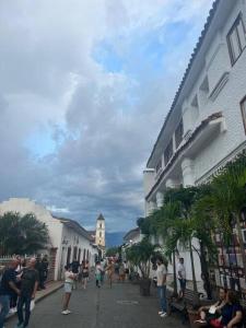 a group of people walking down a street next to buildings at Casa colonial - Jacuzzi - cerca al parque principal - lundry - Tv in Santa Fe de Antioquia