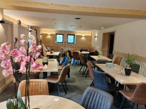 a dining room with tables and chairs and flowers at La Ferme du Praz in Les Contamines-Montjoie