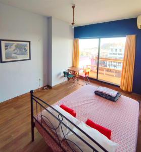 a bedroom with a bed with red pillows and a table at SleepEasy in Athens