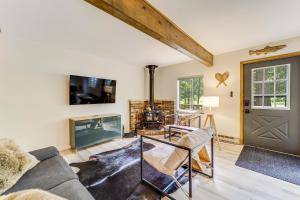 a living room with a couch and a fireplace at Roscommon Chalet with Hot Tub Near Higgins Lake! in Roscommon