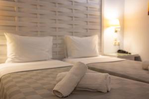 a hotel room with two beds with towels on the bed at Aktaion Resort in Gythio