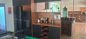eine Küche mit einem schwarzen Kühlschrank und einer Theke in der Unterkunft Casa Espetacular Piscina Aquecida Ofuro Sauna in Caraguatatuba