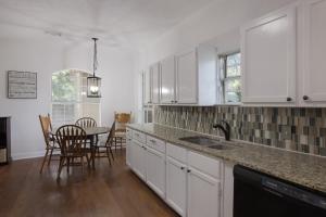 Una cocina con gabinetes blancos y una mesa y sillas. en 126 Lucas Street, en San Antonio