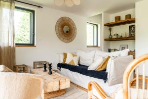 una sala de estar con un sofá blanco con almohadas en Gite d'exception en pleine nature, en Prémanon