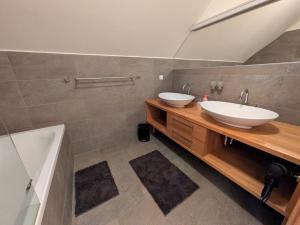 a bathroom with two sinks and a tub at Ferienwohnung SeeTraum Hallstatt in Hallstatt +30 photos