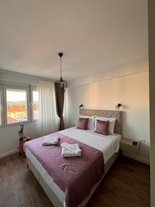 a bedroom with a large bed with two towels on it at Venima City Center Apartment in Tivat