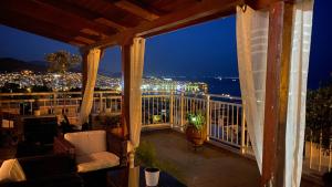 a balcony with a view of a city at night at Estevi Apartment in Kavala