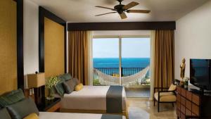 ein Schlafzimmer mit Bett und Blick auf das Meer in der Unterkunft 2BD Del Palmar: Cancun Luxury Resort in Cancún