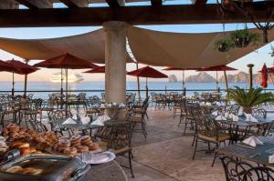 un ristorante con tavoli e sedie con vista sull'oceano di 2BD Del Palmar: Cabo Luxury Resort a Cabo San Lucas