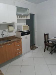 a kitchen with a sink and a microwave at Apê 04 - Confortável e perto de tudo in Vitória da Conquista