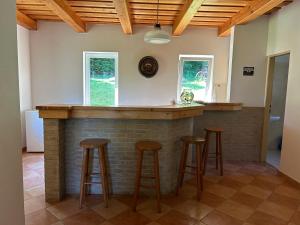 a kitchen with a brick bar with stools at Chata Tomáš - Oravská priehrada in Námestovo