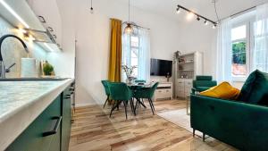 a kitchen and living room with a table and chairs at Apartamenty Kopernika 10 in Frombork