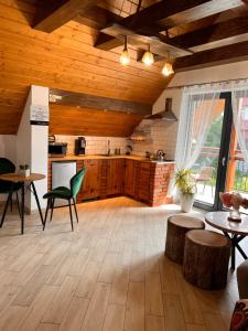 a large kitchen with wooden ceilings and tables and chairs at Domek pod Tatrami Jurgów noclegi in Jurgów