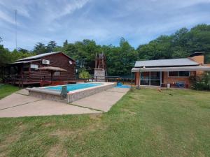 a backyard with a swimming pool and a house at Quinta La Soñada in General Pico