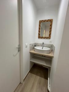 a bathroom with a sink and a mirror at Studio Siana in Chartres