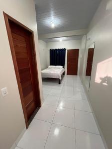 a hallway with a bedroom and a bed in a room at Temporada BHS Quarto 3 in Barreirinhas