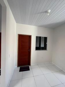 a room with a brown door and a tv at Temporada BHS Quarto 3 in Barreirinhas