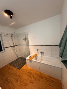 a bathroom with a shower and a bath tub at Traumhafter Ausblick, modern mit Komfort und Stil in Hardert +29 photos