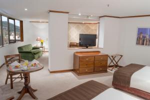 a bedroom with a bed and a tv and a couch at Hotel Bogotá Regency Usaquén in Bogotá +76 photos