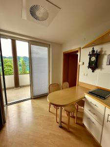 a kitchen with a table and a table and a clock at MB apartment Bled in Bled