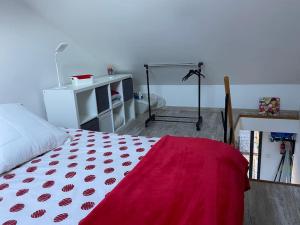 a bedroom with a bed with a red blanket on it at Appartement Cosy JO proche Paris mobilité travail in Deuil-la-Barre