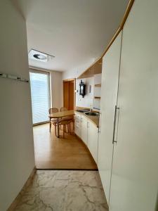 a kitchen with white cabinets and a table in a room at MB apartment Bled in Bled