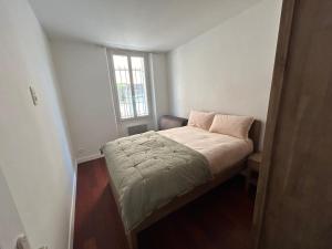 ein kleines Bett in einem kleinen Zimmer mit einem Fenster in der Unterkunft La maison du papé classé 3 etoiles in Bandol