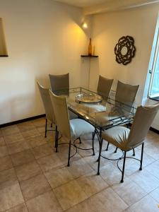 a dining room with a glass table and chairs at Tour de Babel in Sisteron