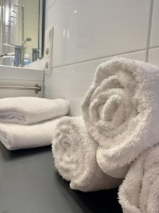a bathroom with a pile of towels on a counter at FeWo Nordsee-Perle Meerblick - Horumersiel in Horumersiel