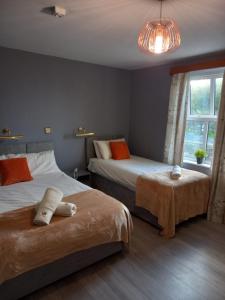 a bedroom with two beds and a window at The Strand, Dugort Achill in Achill