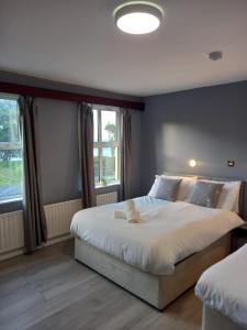 a bedroom with a large bed and two windows at The Strand, Dugort Achill in Achill +29 photos