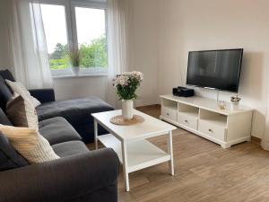 ein Wohnzimmer mit Fernseher, Couch und Tisch in der Unterkunft Cuxhavener Straße 5/3 in Cuxhaven