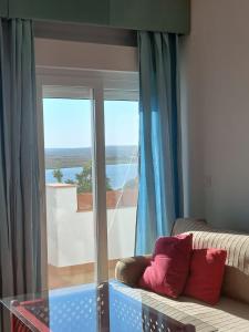 アヤモンテにあるMirador del Guadianaのソファとガラスのテーブルのあるリビングルーム +5枚の写真