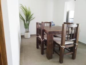 a wooden dining room table and chairs with a plant at Departamento Estrella de Mar in Puerto Vallarta