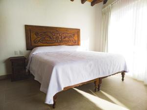 a bed with a wooden headboard in a bedroom at Departamento Estrella de Mar in Puerto Vallarta +4 photos