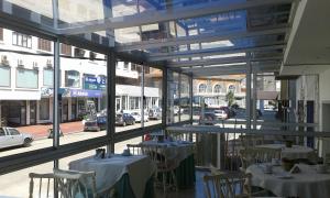 a restaurant with tables and chairs and a view of a street at Hotel Americana in Punta del Este