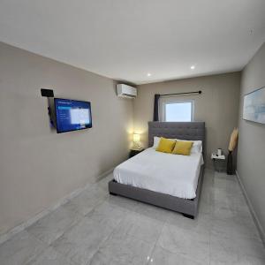 a bedroom with a bed and a tv on the wall at Latitude Adjustment in San Juan
