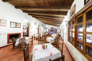 Un restaurante con mesas y sillas y chimenea. en Hotel Taselotzin, en Cuetzalán del Progreso