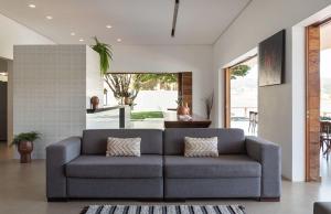 a living room with a gray couch in a house at Pousada Noah in Capitólio