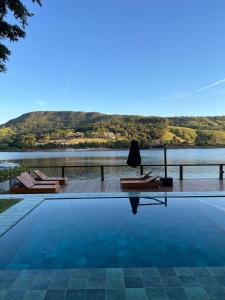 a swimming pool with a view of a lake at Pousada Noah in Capitólio