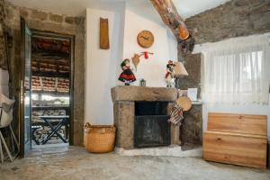 a living room with a fireplace and a clock on the wall at Casa da penha in Picote