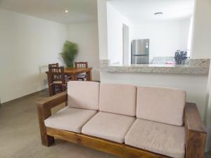 a living room with a couch and a kitchen at Departamento Concha de Mar in Puerto Vallarta