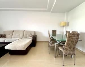 a living room with a couch and a glass table at Vacaciones con el Mediterráneo a menos de 50 metros in Cullera