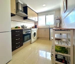 a kitchen with a washer and dryer in it at Vacaciones con el Mediterráneo a menos de 50 metros in Cullera