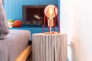 a light on top of a radiator next to a couch at Feel Nazaré - Boat House in Nazaré