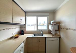 a small kitchen with a sink and a window at Vacaciones con el Mediterráneo a menos de 50 metros in Cullera +21 photos